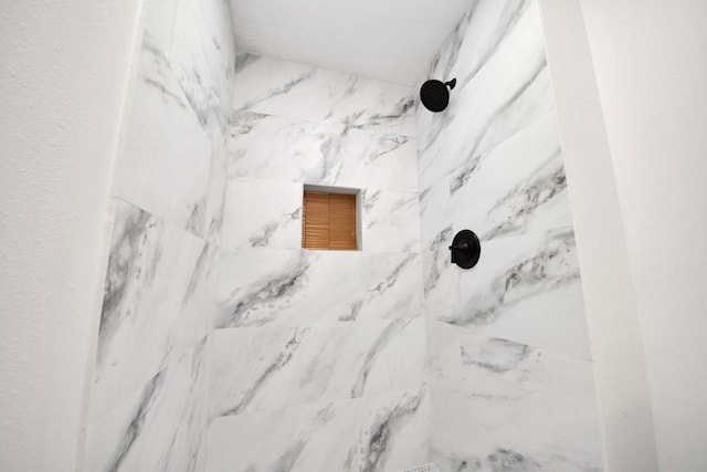 interior details featuring a tile shower