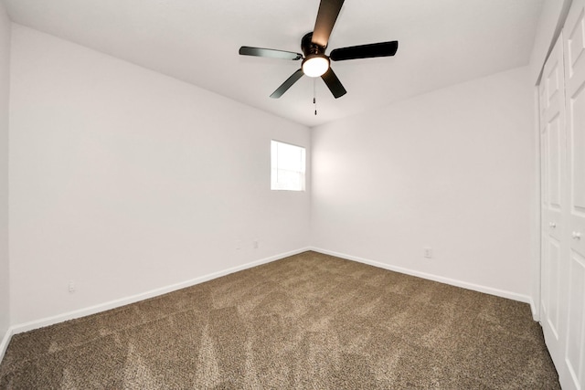 carpeted spare room with ceiling fan