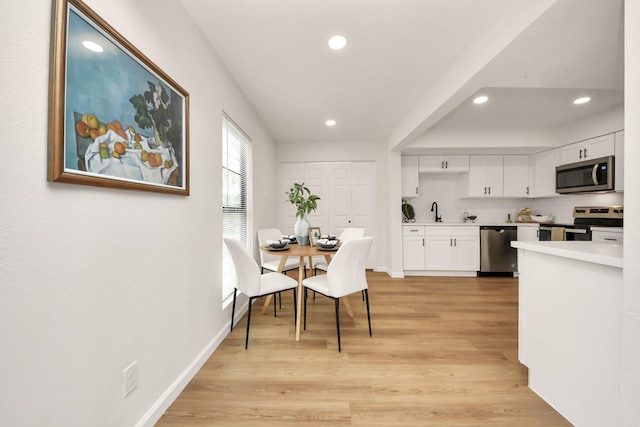 dining room featuring sink and light hardwood / wood-style flooring