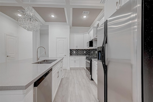 kitchen featuring stainless steel appliances, sink, white cabinetry, tasteful backsplash, and coffered ceiling