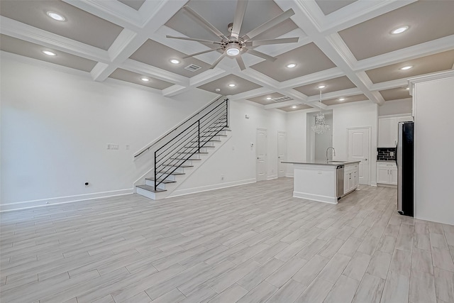 unfurnished living room featuring light hardwood / wood-style floors, coffered ceiling, ceiling fan with notable chandelier, and beam ceiling