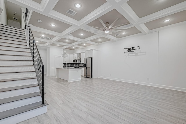 unfurnished living room featuring coffered ceiling, ceiling fan, beam ceiling, and light hardwood / wood-style flooring