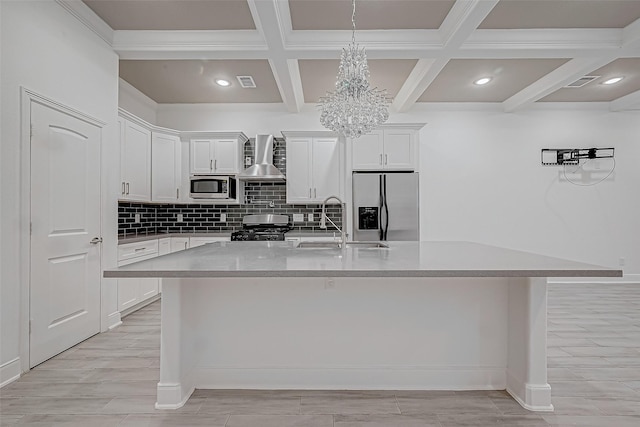 kitchen featuring white cabinets, stainless steel appliances, a kitchen island with sink, and wall chimney exhaust hood