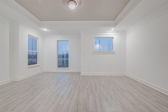 unfurnished room featuring light hardwood / wood-style floors, crown molding, and a tray ceiling