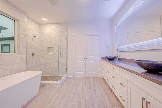 bathroom with vanity, hardwood / wood-style floors, and plus walk in shower