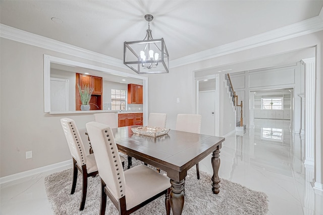 dining area with crown molding and an inviting chandelier