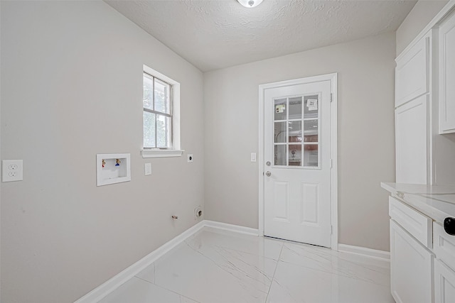 laundry area featuring cabinets, hookup for a washing machine, a textured ceiling, and electric dryer hookup