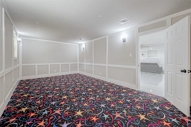 carpeted spare room featuring a textured ceiling