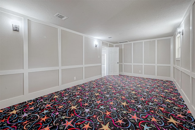 carpeted empty room featuring a textured ceiling