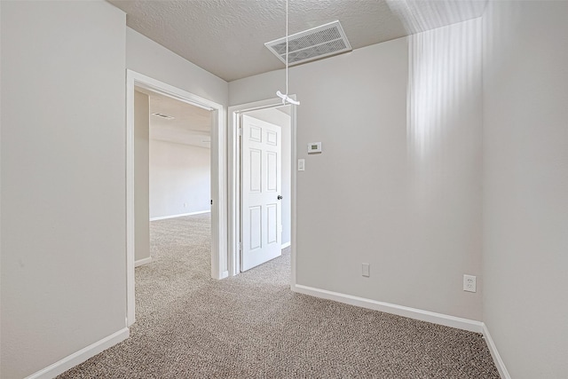 carpeted spare room featuring a textured ceiling