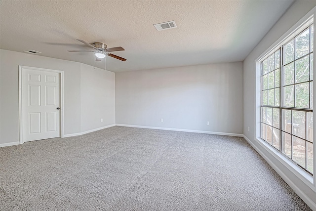 spare room with carpet, ceiling fan, and a textured ceiling