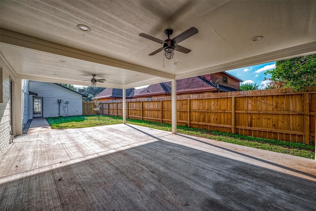 wooden terrace featuring ceiling fan, a yard, and a patio