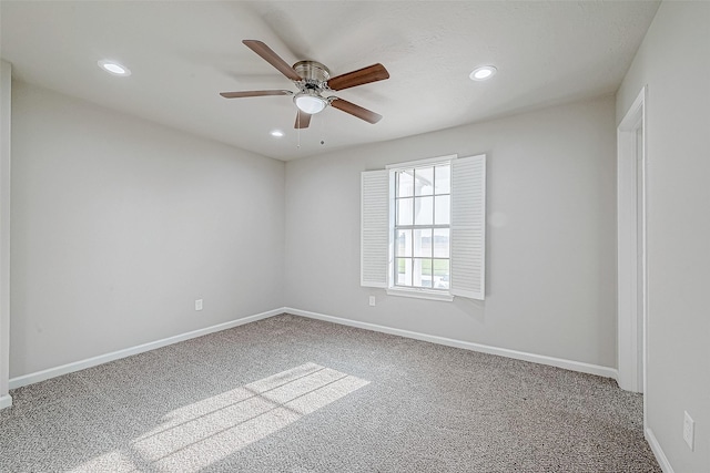 empty room featuring ceiling fan and carpet