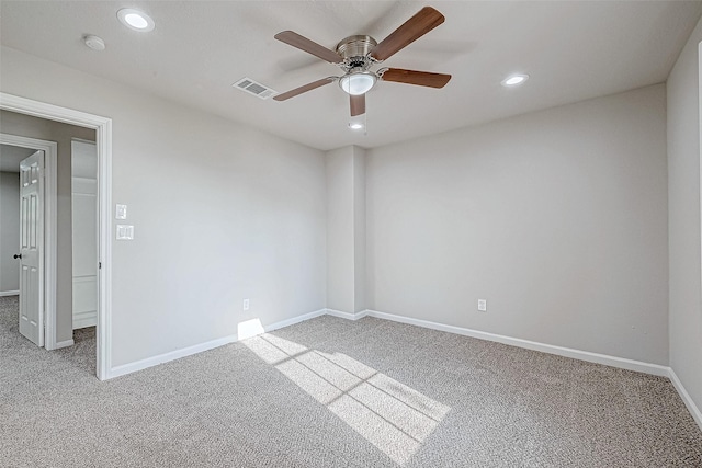 spare room with ceiling fan and light colored carpet