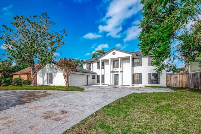 greek revival house featuring a front lawn and a garage