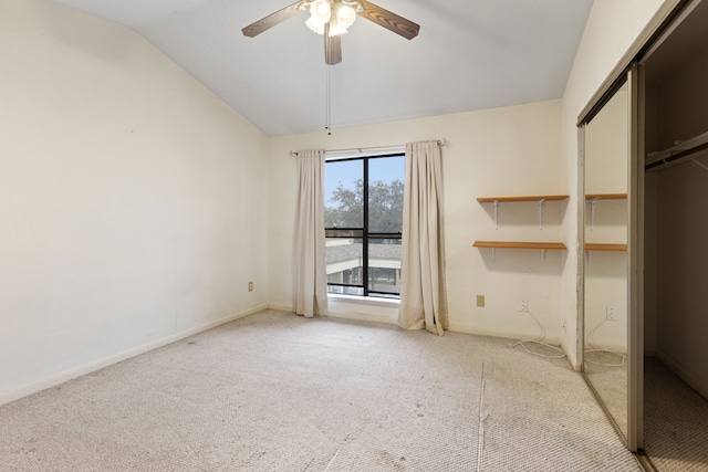 interior space featuring a closet, light colored carpet, vaulted ceiling, and ceiling fan