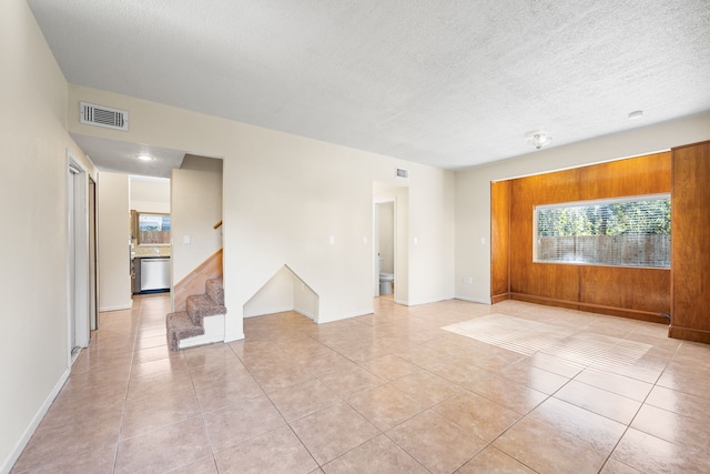 spare room with plenty of natural light, light tile patterned floors, and a textured ceiling