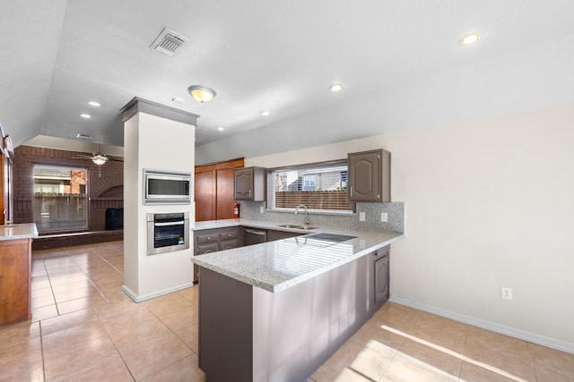 kitchen featuring sink, stainless steel appliances, kitchen peninsula, decorative backsplash, and light tile patterned flooring