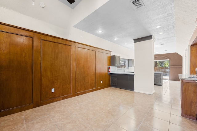 unfurnished living room with a textured ceiling and light tile patterned flooring