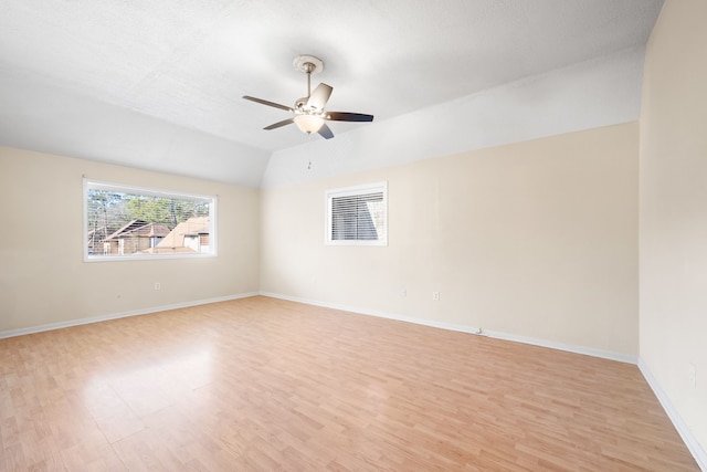 unfurnished room with ceiling fan, lofted ceiling, and light wood-type flooring