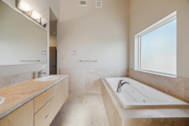 bathroom with vanity and a relaxing tiled tub