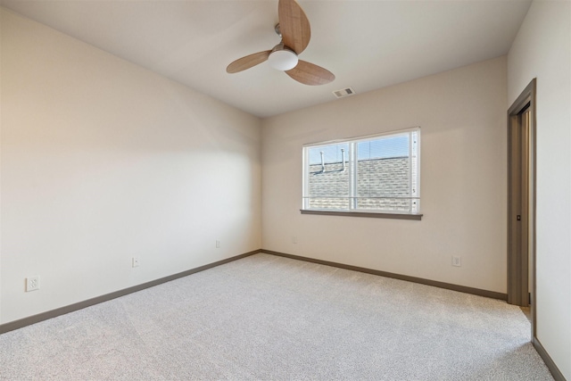 carpeted spare room with ceiling fan