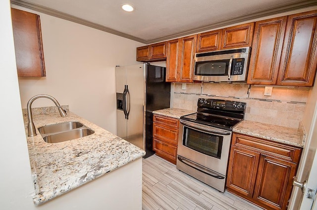 kitchen featuring backsplash, sink, light stone countertops, ornamental molding, and stainless steel appliances