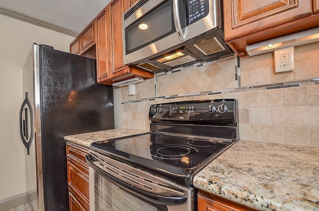 kitchen featuring backsplash, light stone counters, ornamental molding, and stainless steel appliances