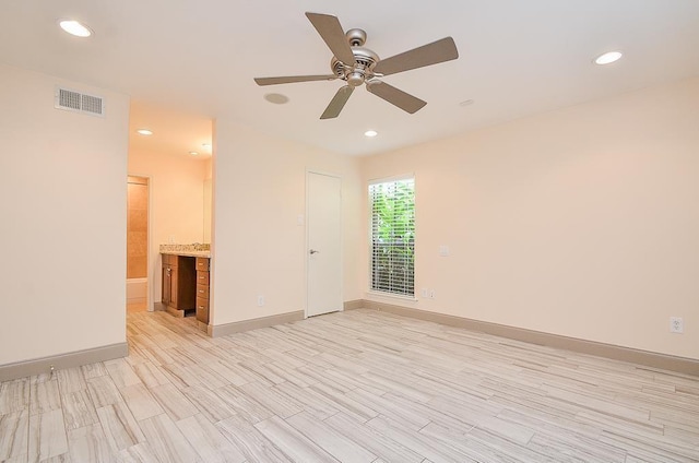 spare room featuring light wood-type flooring and ceiling fan