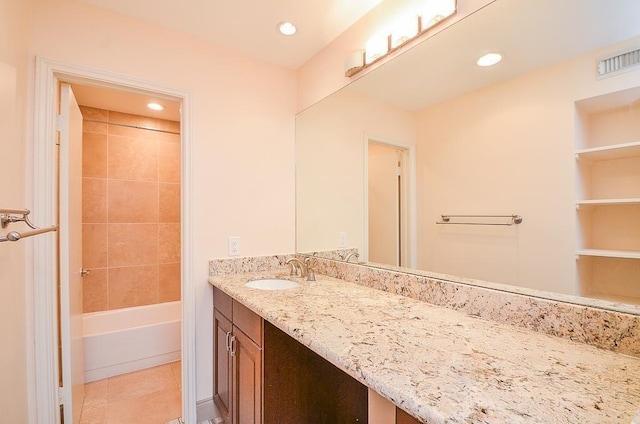 bathroom with tile patterned flooring, vanity, and tiled shower / bath combo