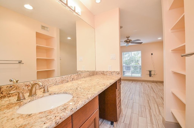 bathroom with wood-type flooring, vanity, built in features, and ceiling fan