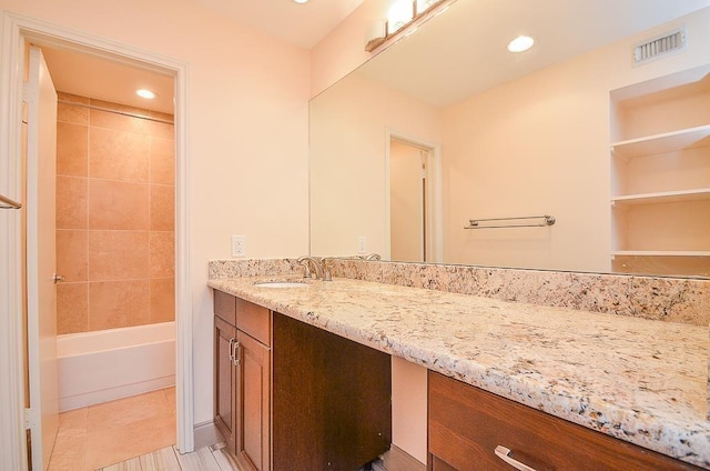 bathroom with vanity and tiled shower / bath combo