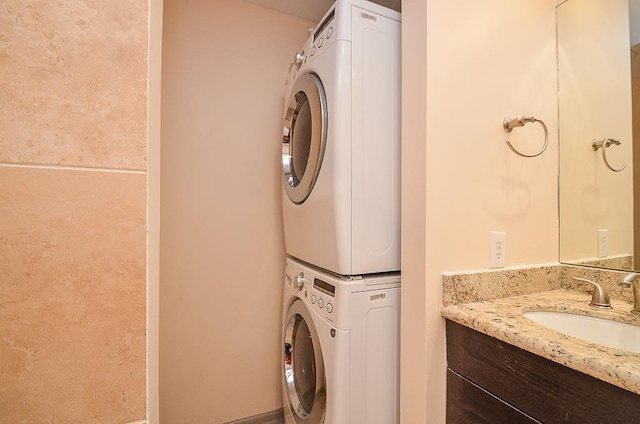 laundry room with stacked washer and dryer and sink