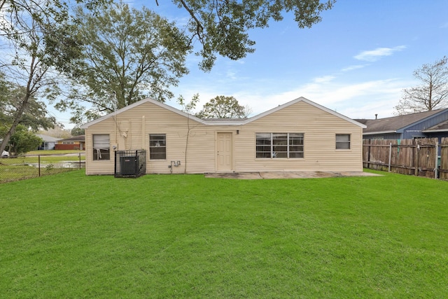 back of property with a yard and central air condition unit