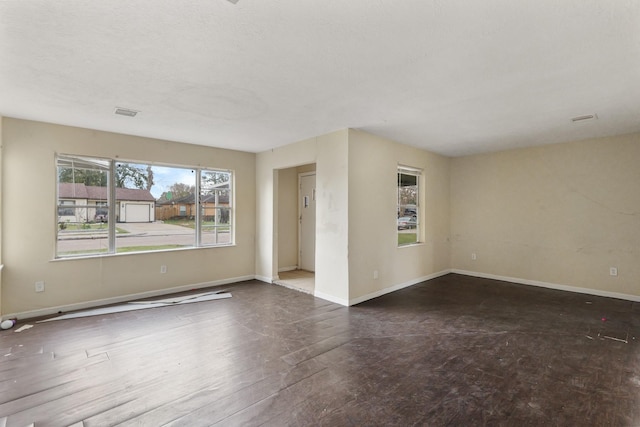 spare room with dark hardwood / wood-style floors and a wealth of natural light