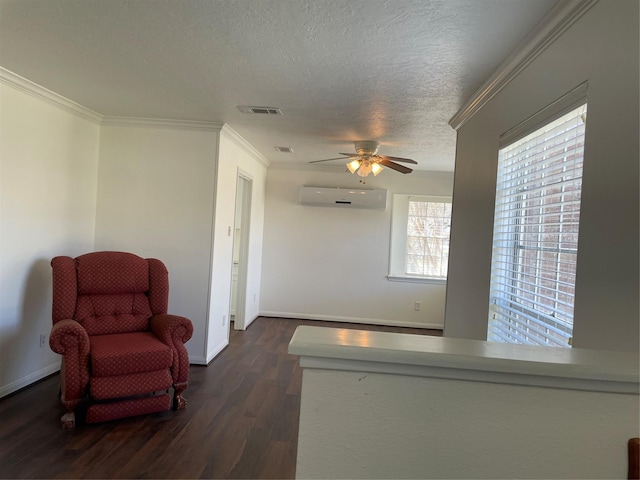 living area featuring ceiling fan, dark wood-type flooring, a wall mounted air conditioner, a textured ceiling, and ornamental molding