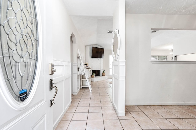 entryway featuring light tile patterned floors and a textured ceiling