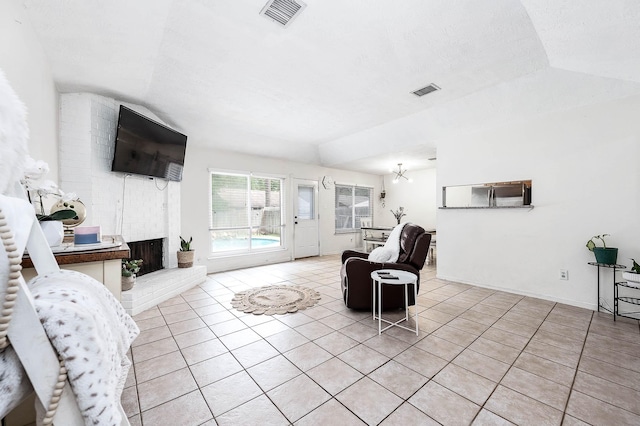 living room featuring a fireplace, light tile patterned flooring, and lofted ceiling