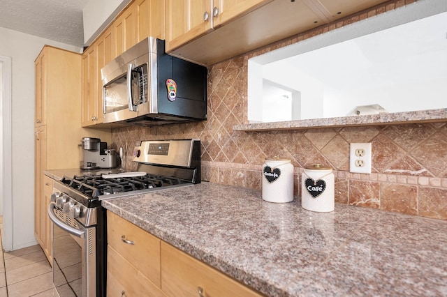 kitchen with backsplash, a textured ceiling, stainless steel appliances, light brown cabinets, and light tile patterned flooring