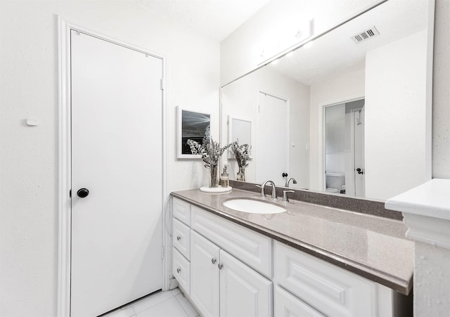 bathroom with tile patterned flooring, vanity, and toilet