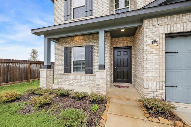 view of exterior entry featuring covered porch and a garage