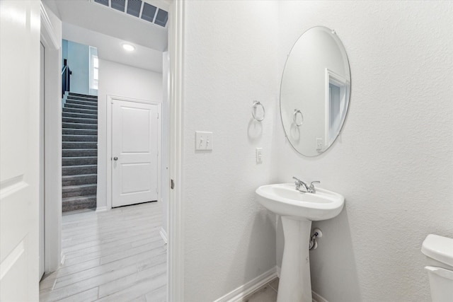 bathroom featuring wood-type flooring and toilet