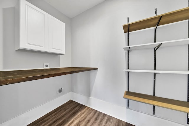 interior space with hookup for an electric dryer, dark hardwood / wood-style floors, and cabinets