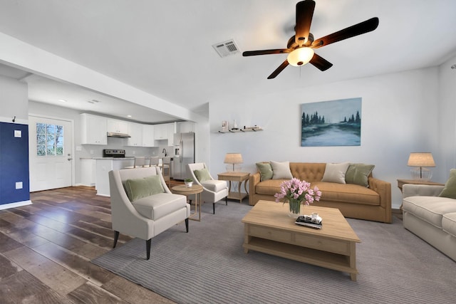 living room with ceiling fan and dark wood-type flooring