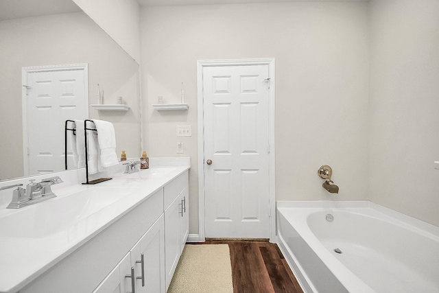 bathroom featuring hardwood / wood-style floors, vanity, and a tub