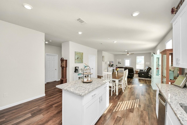 kitchen with white cabinetry, dishwasher, light stone counters, dark hardwood / wood-style flooring, and a kitchen island