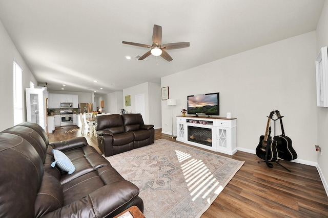 living room featuring ceiling fan and dark hardwood / wood-style flooring