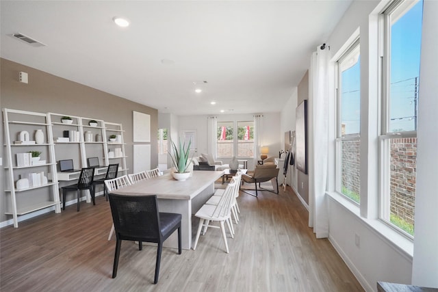 dining area with a wealth of natural light and light hardwood / wood-style flooring