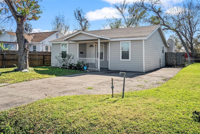 ranch-style home featuring covered porch and a front lawn