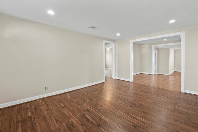 unfurnished room with ceiling fan and dark wood-type flooring